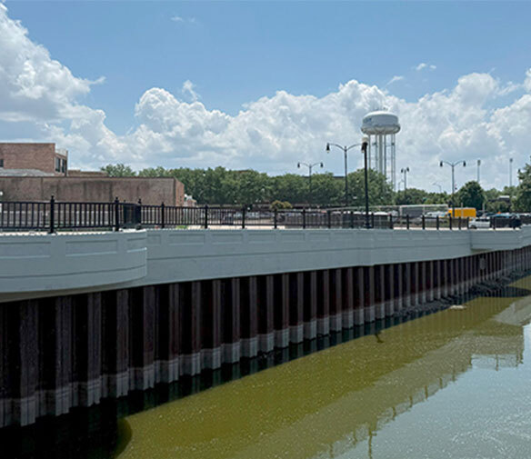 Bridge on body of water in town with water tower in background